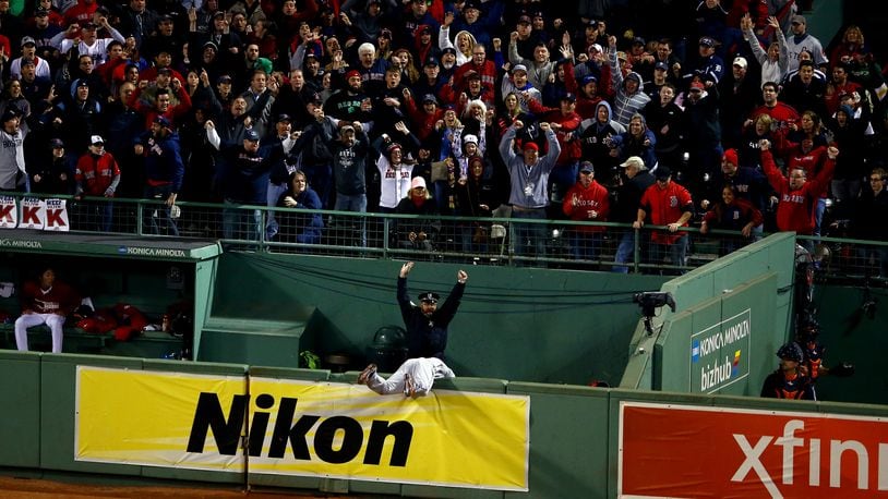 BOSTON, MA - OCTOBER 13:  Torii Hunter #48 of the Detroit Tigers falls over the bullpen fence after trying to catch a grand slam hit by David Ortiz #34 of the Boston Red Sox as Boston Police Officer Steve Horgan celebrates in the eighth inning as Boston police officer Steve Horgan cheers in Game Two of the American League Championship Series at Fenway Park on October 13, 2013 in Boston, Massachusetts.  (Photo by Al Bello/Getty Images)