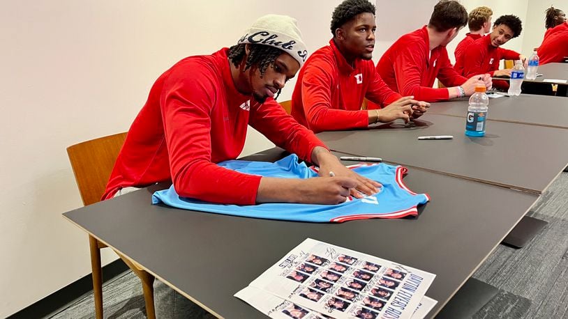 Dayton players DaRon Holmes II, left, and Makai Grant sign autographs before "The Spotlight, To Shine A Light On Mental Health" at UD Arena on Thursday, Oct. 19, 2023. David Jablonski/Staff