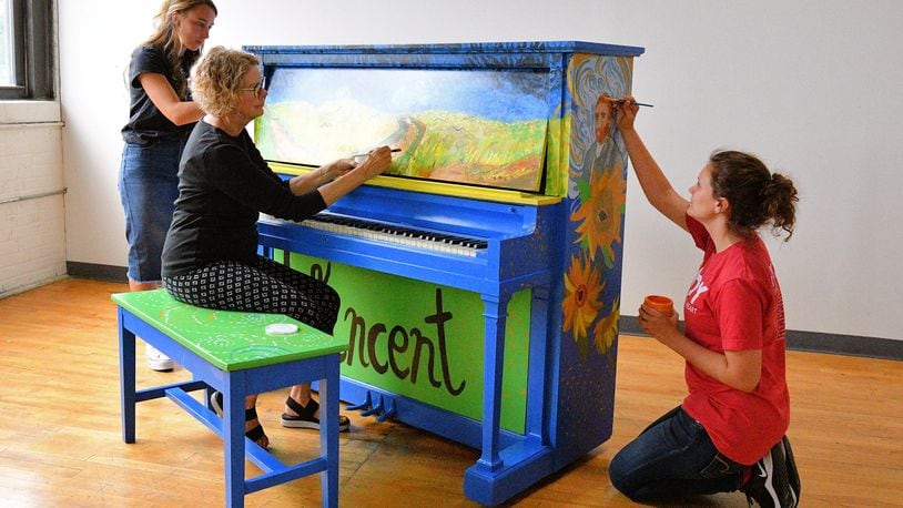 Annette Cargill works on a piano for the Troy downtown pianos project with the assistance of Abigail Twiss (left) and Ellie Wannemacher (right). Contributed photo