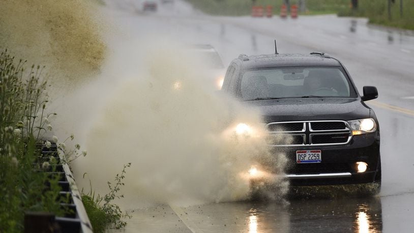 A vehicle drives through water on Liberty Way in Liberty Twp. in mid-July. NICK GRAHAM/STAFF