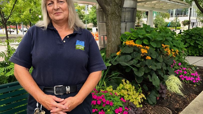 Cinda Plante stands for a photo in front of a bed of flowers at Riverscape Metropark.