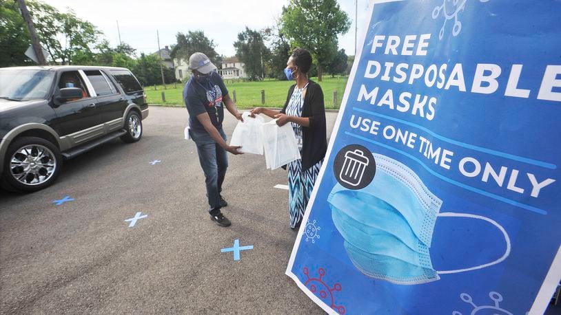 Gilbert Ghand, left, and Angela Boykin, with Dayton & Montgomery Public Health, help to giveaway free disposable mask Monday, Aug. 17, 2020, at the Mount Olive Baptist Church. MARSHALL GORBY\STAFF